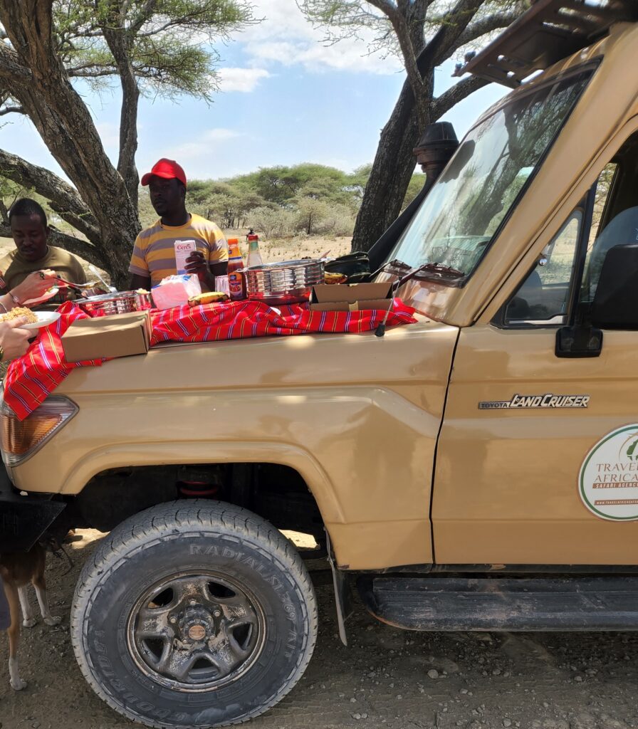 red table cloth on top of jeep with food spread out