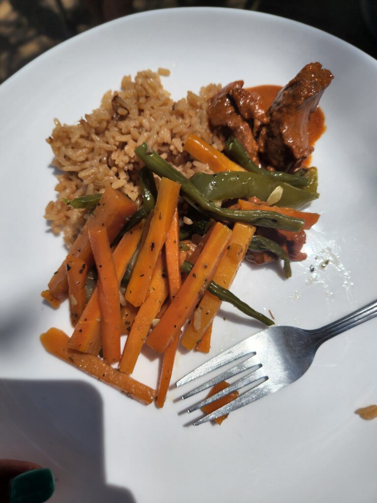 rice, carrots, and beef curry on white plate with silver fork