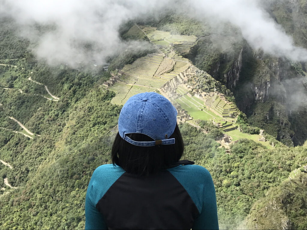 Woman looking down on Machu Picchu ruins from Waynapicchu 
